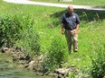 Dan Wood, Kingsville's then manager of parks and recreation, inspects the bank of Lakeside Park's Mill Creek in 2012.