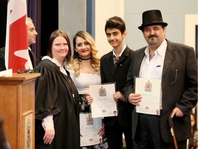 Admon Oshana, right, proudly poses with his son, Dankha Dankha, 14, and daughter Oneila Dankha, 20, and IRCC supervisor Kristy Greenslade, left, as 40 new Canadians from 17 different countries received their Certificate of Citizenship at Cardinal Carter High School Auditorium in Leamington on March 8, 2017. Hundreds of students from Cardinal Carter witnessed the event and everyone sang O Canada before attending a reception. Behind left, IRCC clerk Dan Fanelli prepares for the next presentation. Admon Oshana and his family came to Canada from Iraq in 2012.