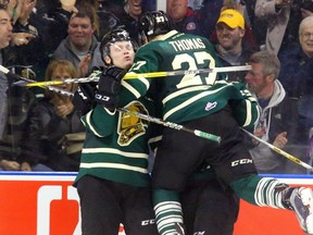 Max Jones of the London Knights makes it 4-2 with an empty-netter and is congratulated by linemates Cliff Pu and Robert Thomas late in the third period of an OHL playoff game on March 26, 2017 at Budweiser Gardens in London, Ont.