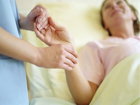 A nurse checks a female patient's pulse.