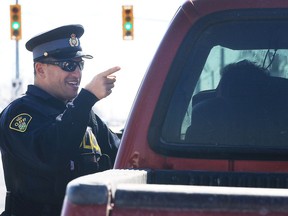 Ontario Provincial Police Const. Jeremy Kulwartian speaks to a driver he pulled over on Walker Road on March 16, 2017 that was texting while driving.