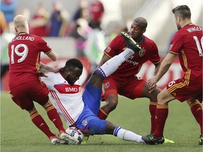 Real Salt Lake midfielder Luke Mulholland (19),  Chris Schuler (28) and Chris Wingert (16) defend Toronto FC forward Jozy Altidore (17) as he falls to the pitch during an MLS soccer game on March 4, 2017 in Sandy, Utah.