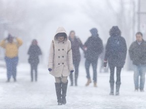 Pedestrians walk along Sunset Avenue on the University of Windsor campus during a winter storm on March 13, 2017.