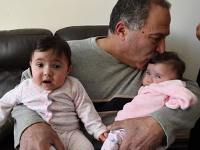 Edward Haddad holds his two nine-month-old daughters, Mary and Rafqa, at his Tecumseh home on March 15, 2017. Haddad's wife, Noha, died suddenly on March 13, 2017. Now, the grieving husband is frustrated in his efforts to get his wife's body back to her native Lebanon.