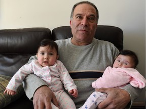 Edward Haddad holds his two daughters at his Tecumseh, Ont., home on March 15, 2017.