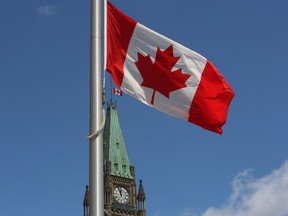 The Canadian flag flies above the Peace Tower on Parliament Hill on June 23, 2015.
