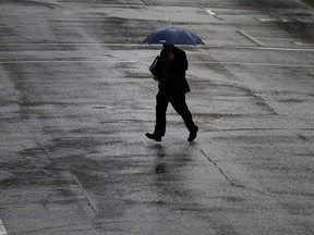 A man walking in downtown Windsor uses an umbrella against the rain on Feb. 7, 2017.