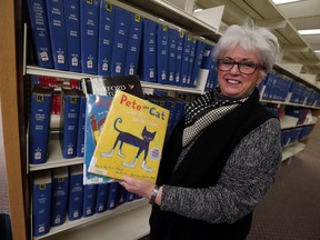 Windsor Public Library CEO Kitty Pope holds up some of the library's most popular books at the downtown branch in Windsor on Jan. 19, 2017.