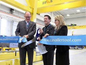 Windsor Mayor Drew Dilkens, left, Cavalier Tool and Manufacturing Ltd. president Brian Bendig and GM Brenda Quint cut the ribbon underneath Cavalier's newly installed 50,000 kilogram crane in their advanced assembly area March 29,2017.