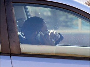 A driver holds a cellphone to his right ear while waiting to turn from northbound Ouellette Avenue to Wyandotte Street West on March 10, 2017.