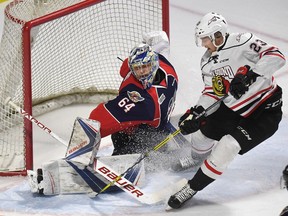 Windsor Spitfires goaltender Michael DiPietro makes a save against Owen Sound Attack forward Matt Schmalz during first-period Ontario Hockey League action at the WFCU in Windsor, Ont., on March 16, 2017.