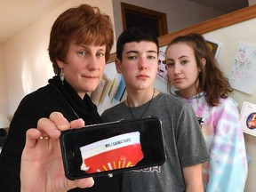 Nicole Morin, left, with children John, 13, and Katie, 14, at their Windsor, Ont., home on March 22, 2017. The family is upset that they were denied the $100 prize from a Tim Hortons Roll up the Rim to win cup.