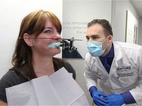 Patient Laurie Lewicki is examined by Eric D. Kukucka, right, at The Denture Center on Lauzon Parkway March 29, 2017. Lewicki is one of the first to receive Ivoclar digital dentures.