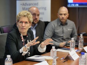 Premier Kathleen Wynne, left, Brian Bilger, Detroit Regional Chamber, and Paul DiGiovanni, right, of Integrity Tool, are seen during a roundtable discussion at the WindsorEssex Economic Development Corporation on March 30, 2017.