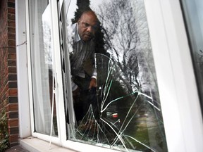 Ward 2 Coun. John Elliott inspects the damage after someone threw a rock through the window of his Windsor home.