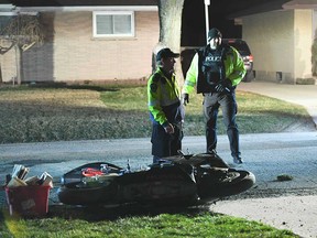 Windsor police officers stand by a wrecked motorcycle in the 3000 block of Woodlawn Avenue on the night of March 22, 2017.
