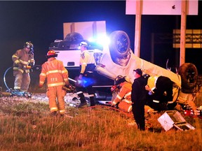 Emergency crews work to rescue a driver after a pickup truck flipped over on the offramp at Highway 401 at Provincial Road on April 13, 2017.