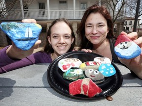 Cayley Baetens, left, and Jen Ibrahim hold some of Amherstburg's painted rocks at the historic Gordon House on Dalhousie Street on April 11, 2017.