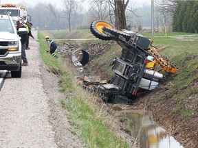 A large field sprayer sits in a ditch after rolling over on Alma Street on April 20, 2017.
