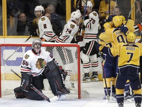 Chicago Blackhawks goalie Corey Crawford looks up at the scoreboard as Nashville Predators players celebrate a goal by Filip Forsberg during the third period in Game 3 of a first-round NHL hockey playoff series on April 17, 2017, in Nashville, Tenn. The Predators won 3-2 in overtime to take a 3-0 lead in the series.