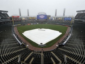 A rain tarp covers the field at Guaranteed Rate Field during a rain delay on opening day before an MLB baseball game between the Chicago White Sox and Detroit Tigers, Monday, April 3, 2017 in Chicago.