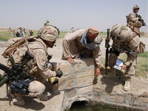 Canadian military engineers with the Provincial Reconstruction Team during the Afghanistan mission help assess a bridge crossing during a village visit west of Kandahar City.