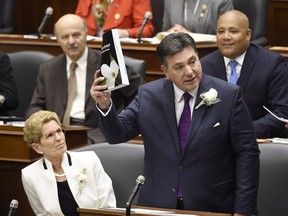 Ontario Finance Minister Charles Sousa, right, delivers the 2017 Ontario budget next to Premier Kathleen Wynne at Queen's Park in Toronto on April 27, 2017.