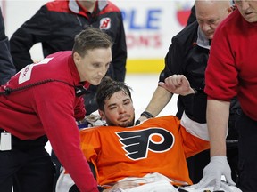 Philadelphia Flyers goalie Michal Neuvirth gives a thumbs-up as he is taken off the ice on a stretcher after collapsing to the ice early in the first period against the New Jersey Devils, Saturday, April 1, 2017, in Philadelphia.