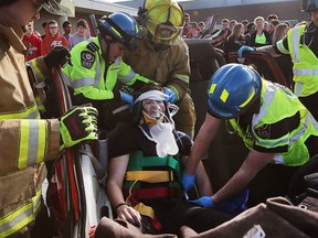 Paramedics and firefighters extricate a victim in a mock accident on April 26, 2017 at Tecumseh Vista Academy. The simulation was part of a day-long event to highlight the dangers of distracted and impaired driving.