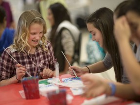 Melanie Owen, 11, left, and Miranda Parlee, 11, both Grade 6 students from St. Joseph Catholic Elementary School, paint tiles for the Canada 150 Mosaic at the Vollmer Culture and Recreation Complex in LaSalle on April 6, 2017.