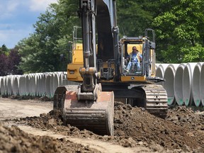A heavy equipment operator works on the Lakewood Park sewer improvement project on July 16, 2014, in Tecumseh.