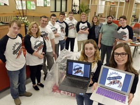 Jordyn Tocco, foreground left, and Sydney Tocco, display the Team Sabotage - FIRST Robotics Team 6331 logo while standing with other team members Paul Labbé, left, Monique Pouget, Peter Tenzer, Daniel Cecile, Zack Pouget, Jonas Delaurier, Vlad Jidkov, Julie Fortin, Serge Brosseau and Robert Zompanti at L'Essor high school in Tecumseh.