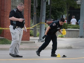 Windsor police officers investigate the scene of a shooting near a Tim Hortons at the corner of Wyandotte Street East and Walker Road on Wednesday, June 22, 2016.