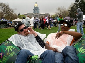 Festival-goers share a joint during the Denver 420 Rally at Civic Center Park in Denver, Colo., on April 20, 2017.