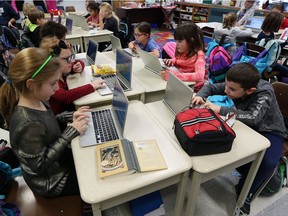 A Grade 3 class work on a programming lesson at St. Rose Catholic Elementary School in Windsor. The provincial government announced Wednesday that overall class sizes will be reduced beginning this fall.