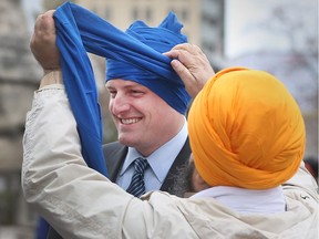 Harjinder Singh Kandola, president of the Sikh Cultural Society of Metropolitan Windsor, wraps a turban on Windsor Mayor Drew Dilkens while joining members Sikh community in celebrating Sikh Heritage Month and Khalsa Day celebration at Windsor City Hall on April 13, 2017 in Windsor, Ontario.