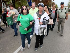 Marlene Affleck, right, walks with her daughter Tina and husband Don Affleck, behind, during the National Day of Mourning service at St. Augustine Church on Wyandotte Street East Friday April 28, 2017.