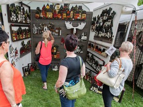 Attendees of Windsor's Art in the Park 2016 look over some handcrafted goods.