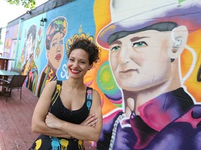 Windsor mural artist Briana (Athena) Benore stands in front of the 900-square-foot piece she painted overlooking the patio of the Dominion House tavern, May 29, 2017.