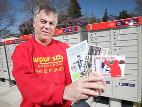 Phil Lyons, president of CUPW Local 630 is shown on May 8, 2017, displaying the postcards his members will be distributing throughout the city. Postal carriers are pushing for more door-to-door delivery. Lyons poses at Clairview and Clover where several curbside mail boxes are located.