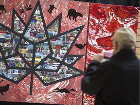 A passerby takes a photo of an art piece celebrating Canada's 150th birthday that was unveiled at Devonshire Mall, Monday, May 1, 2017. The commemorative piece was designed by Canadian artists Andrea Mercier and Arlene Murphy.