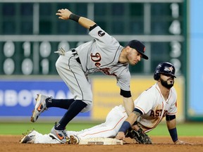 Marwin Gonzalez of the Houston Astros dives back into second base before Ian Kinsler of the Detroit Tigers can apply the tag in the eighth inning at Minute Maid Park on May 23, 2017 in Houston, Texas.