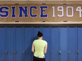 A Harrow District High School student gets into her locker under a 'Since 1904' sign on June 16, 2016. Despite community lobbying, the rural high school was closed last year.
