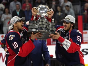 Windsor Spitfires Jeremiah Addison, left, and defenceman Jalen Chatfield raise the trophy after defeating the Erie Otters to win the Memorial Cup in Windsor on May 28, 2017.