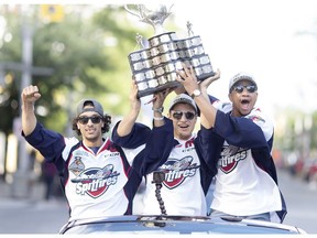 Windsor Spitfires Jalen Chatfield, left, Cristiano DiGiacinto and Jeremiah Addison hoist the Memorial Cup during the Windsor Spitfires Memorial Cup victory parade in downtown Windsor on May 31, 2017.