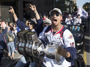 Windsor Spitfires Jeremiah Addison hoists the Memorial Cup during the victory parade in downtown Windsor on May 31, 2017.