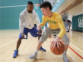 St. Clair Saints men's basketball coach Ricardo Tate, left, works with team member William Lara-Caston during practice on May 10, 2017 at the St. Clair SportsPlex.