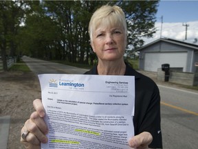 Gisele McLarty holds a notice from the Municipality of Leamington on May 30, 2017, notifying her that her bill will increase from $10,800 to $17,500 for sewer work outside her home on Point Pelee Drive.