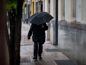 A pedestrian carries an umbrella in downtown Windsor on May 4, 2017.