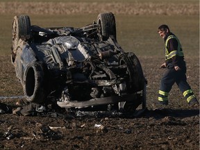 A tow truck driver prepares to remove a wrecked car in a field along Concession 4 in Amherstburg on Feb. 13, 2017.